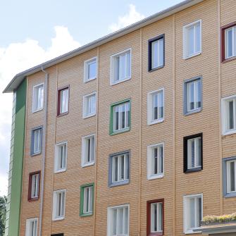 Vantaan Kivistössä sijaitsevan Opaalitalon ikkunat, joissa erivärisiä ikkunakarmeja. Yhdellä ikkunalla kukkaruukku.